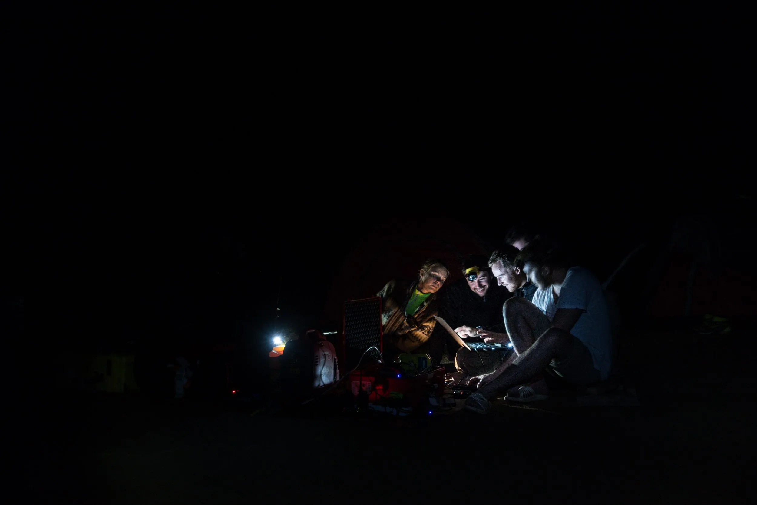 The Son Doong 360 team working together from a single laptop in the darkness of the largest cave in the world.